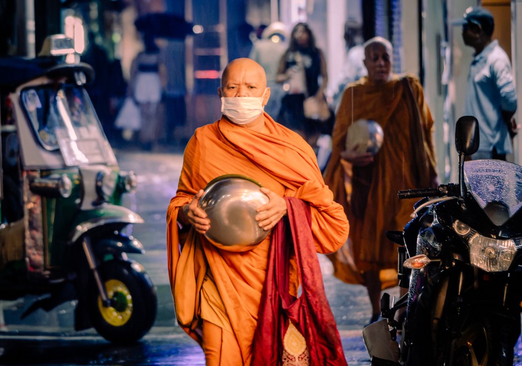 A Monk walks along Sukhumvit in the early hours of the morning.